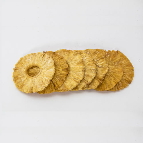 Rodajas de piña deshidratada apiladas sobre fondo blanco — Alma Tropical